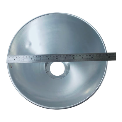 A silver metal conical reflector with a central circular opening, shown with a metal measuring tape across the opening to indicate size, on a plain white background.