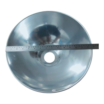 A large silver metal reflector or lamp shade shown from above on a white background, with a measuring tape laid across the front to indicate size.