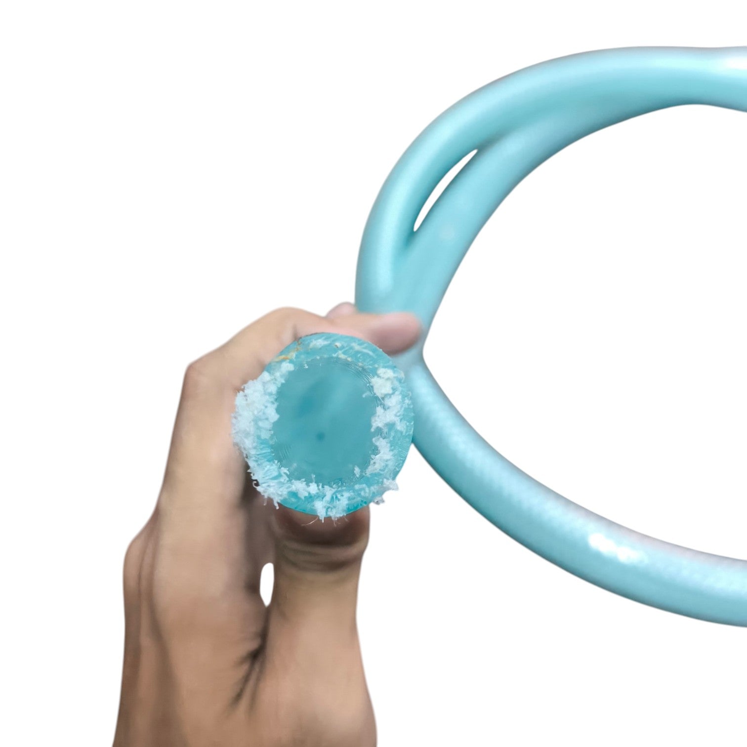 Hand holding a blue ring with a textured surface against a white background