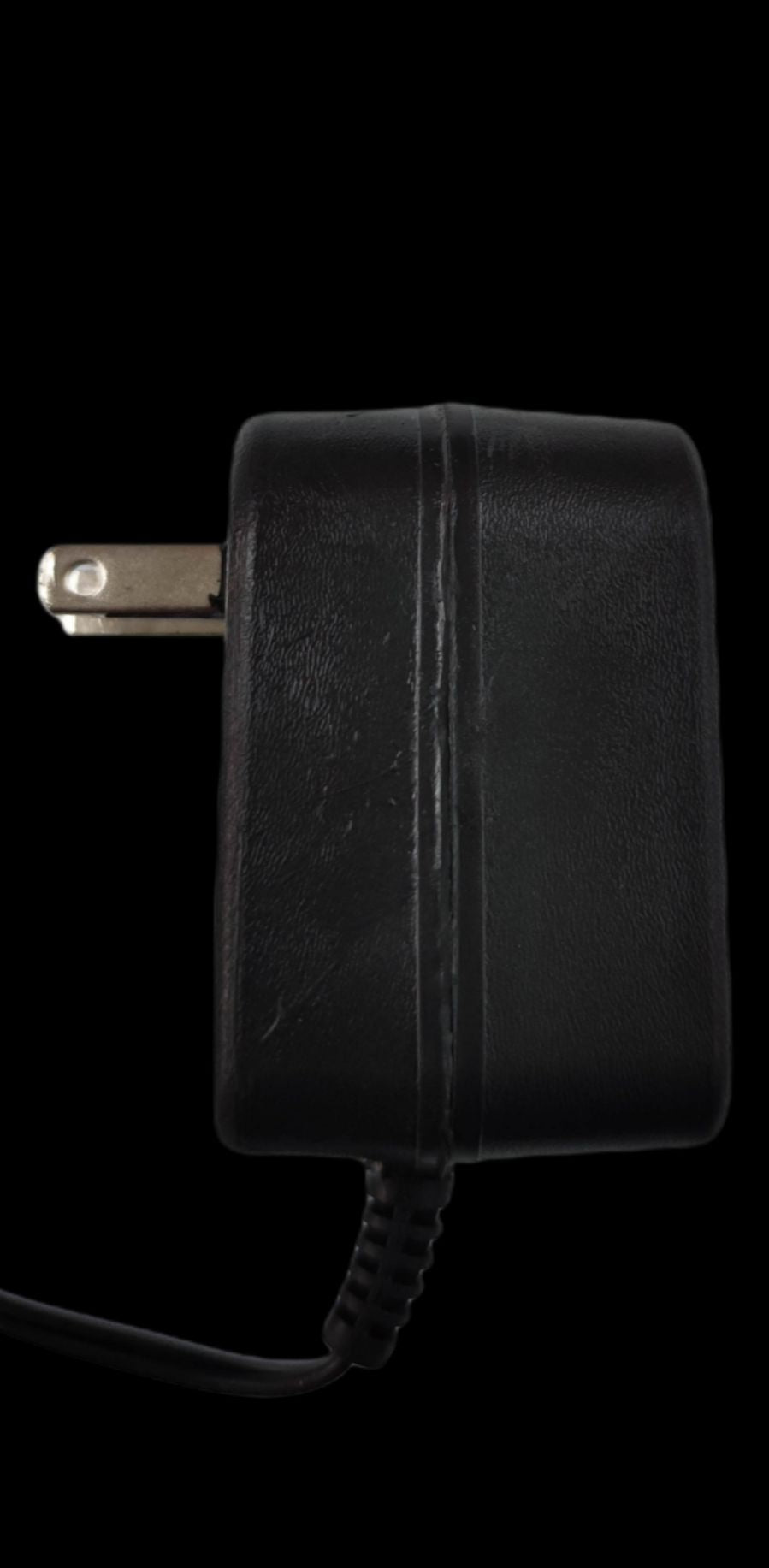 Black wall charger from China designed as a cellphone charger for Ericson old mode with plug and cable
