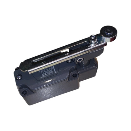 A heavy-duty industrial mechanical component, likely a hydraulic or pneumatic valve block with a lever arm, featuring a dark gray cast metal body and a polished silver metal lever with a black knob, isolated on a white background.