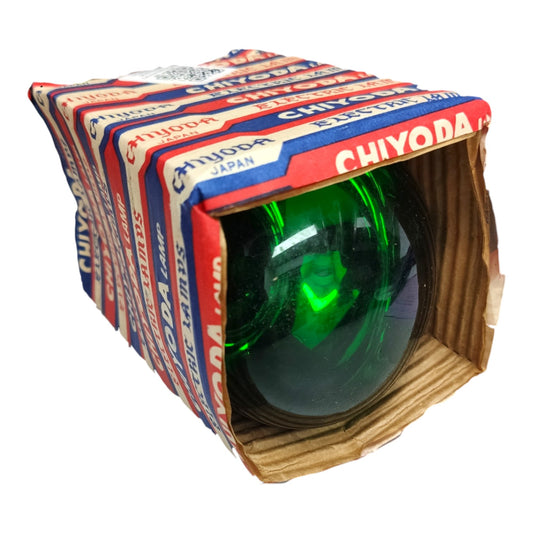 A vintage Chiyoda glass obelisk lantern with a green-tinted glass sphere inside, housed in a cardboard box wrapped in branded Chiyoda paper.