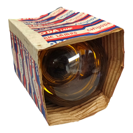 A vintage clear glass car windshield with an amber tint, sealed inside a cardboard display box with red, white, and blue printed labels. The box is shown on a solid white background.
