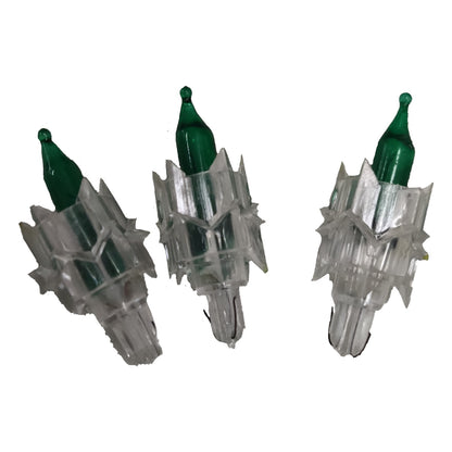 Three clear plastic Christmas tree lights with green bulbs on a white background