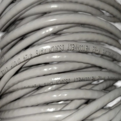 Close-up of coiled gray Ethernet cable with printed text reading NETCONNECT CS300M RJ45 5/25 UFTP 1000BASE-T.