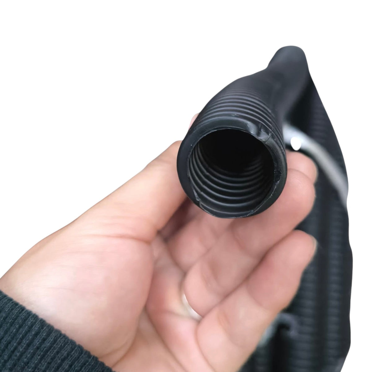 A close-up of a hand holding a black corrugated hose connector fitting against a plain white background.
