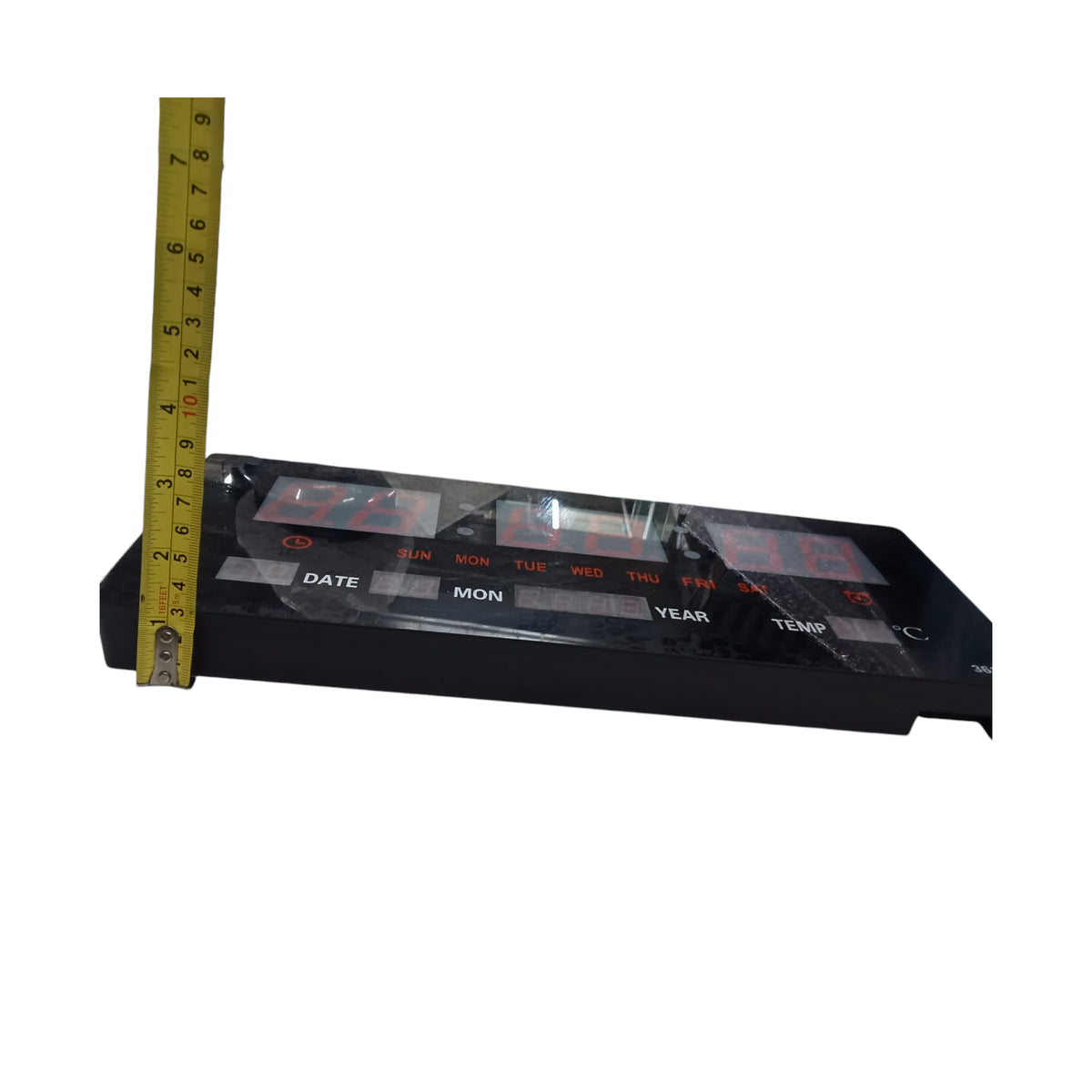 Digital wall clock 220V displaying time, date, and temperature with measuring tape for size reference