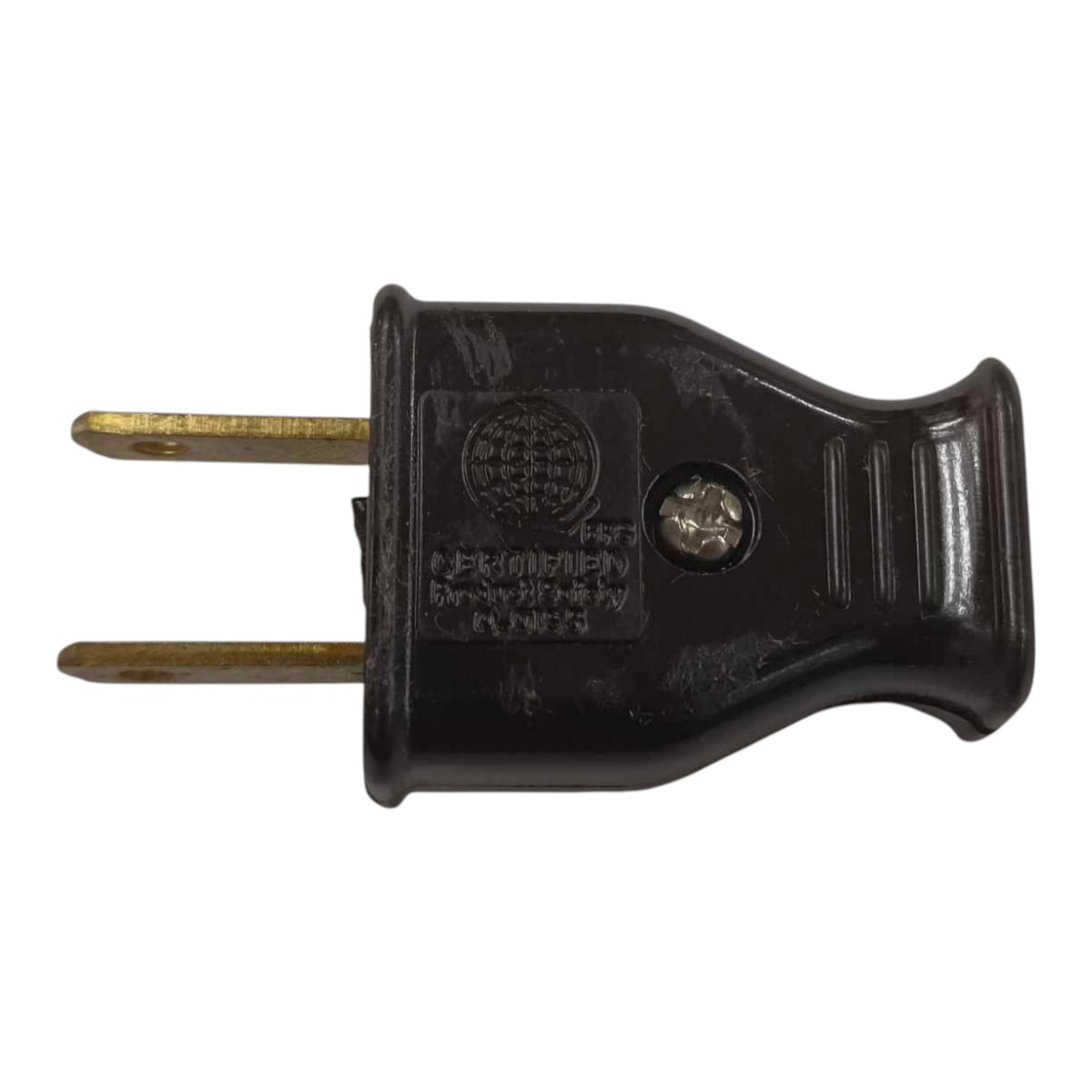 A black plastic two-prong electrical plug with brass-colored metal pins, featuring molded text and a circular emblem on the side.
