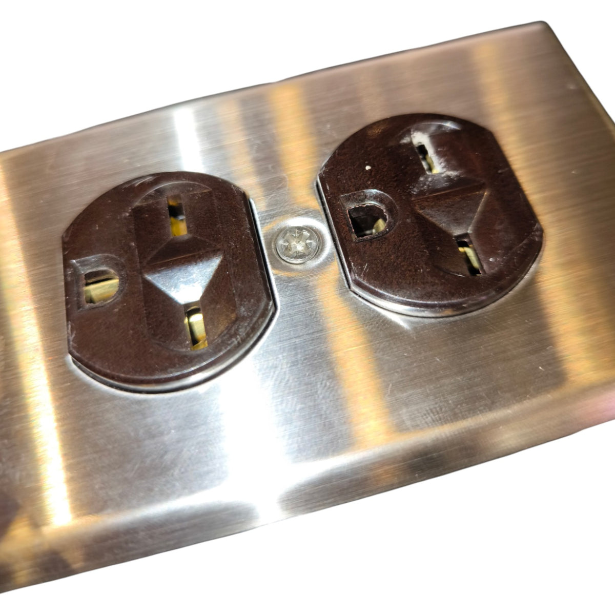 A brushed stainless steel double outlet cover plate with two dark brown electrical outlets, shown on a plain white background.
