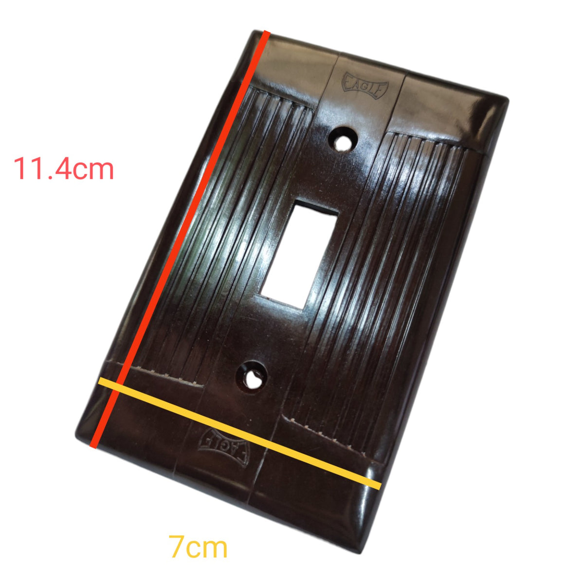 A glossy black plastic double-gang light switch plate shown at an angle with red and yellow measurement lines and text indicating dimensions 11.4cm and 7cm on a white background.
