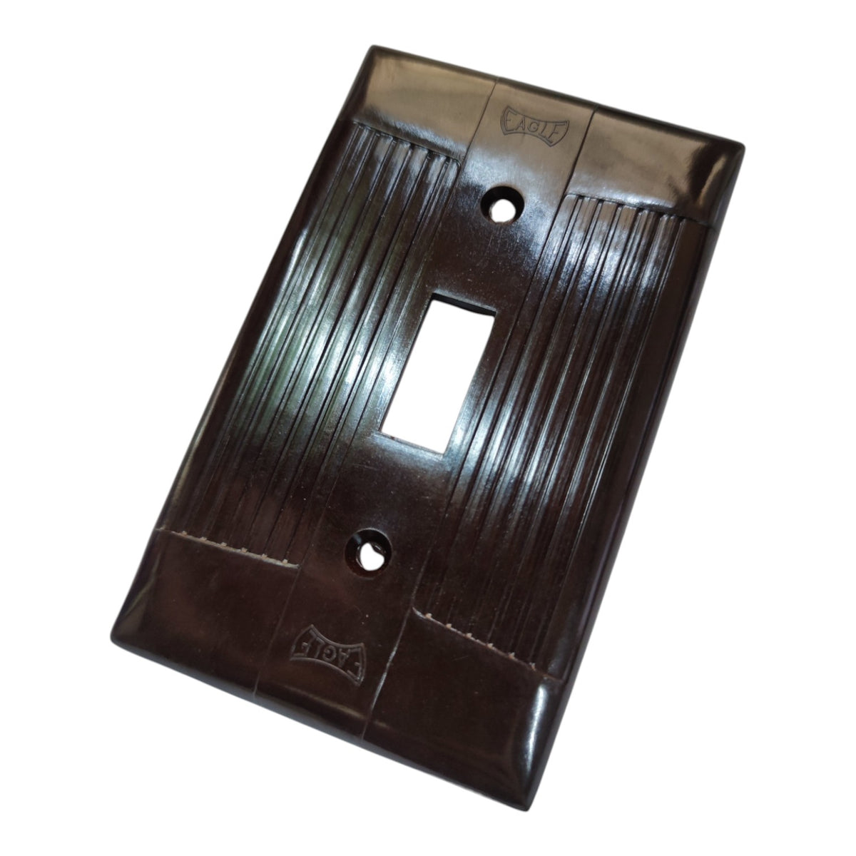 A dark brown glossy switch plate with a ribbed vertical pattern and a rectangular cutout in the center, shown on a plain white background.