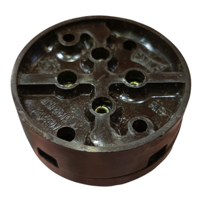A dark brown cast iron or steel mechanical component with multiple circular holes and embossed text, shown on a plain white background.