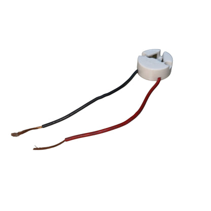 A small white plastic electrical component with two exposed wires, one black and one red, on a plain white background.
