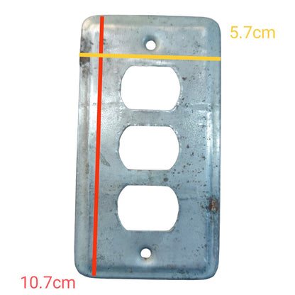 A weathered metal three-outlet electrical wall plate shown on a white background with red and yellow measurement lines and text indicating dimensions 10.7cm and 5.