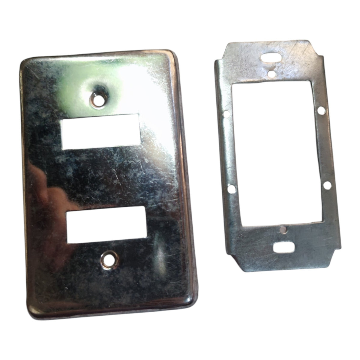 Two metallic electrical outlet covers or faceplates shown on a plain white background, one with two rectangular cutouts and one with a larger single cutout.