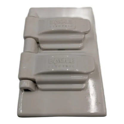 A single white plastic electrical outlet cover plate with the brand name 'BAGUE ELECTRIC' embossed on the top cover, shown against a plain white background.