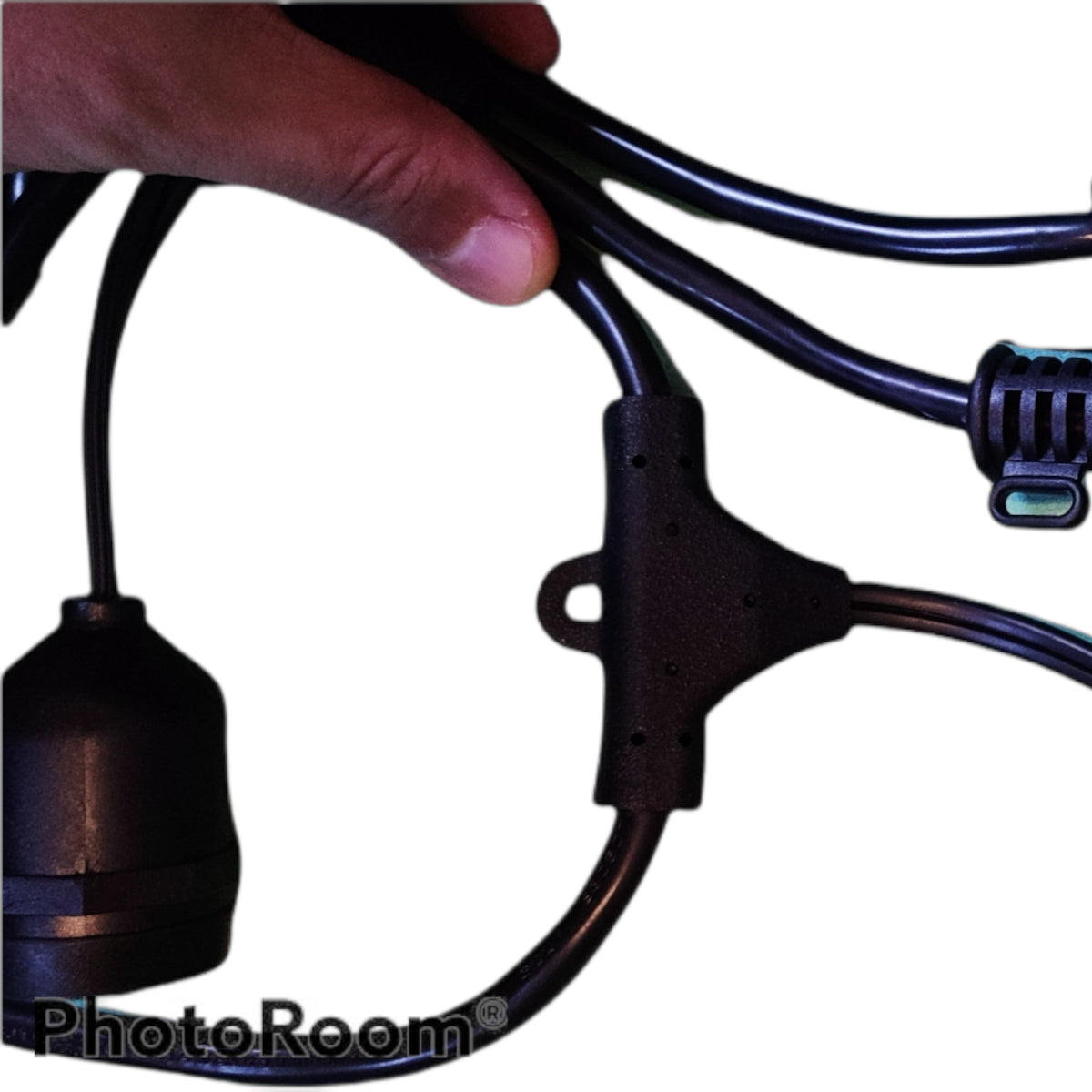 Hand holding a black electrical cable with connectors on a white background