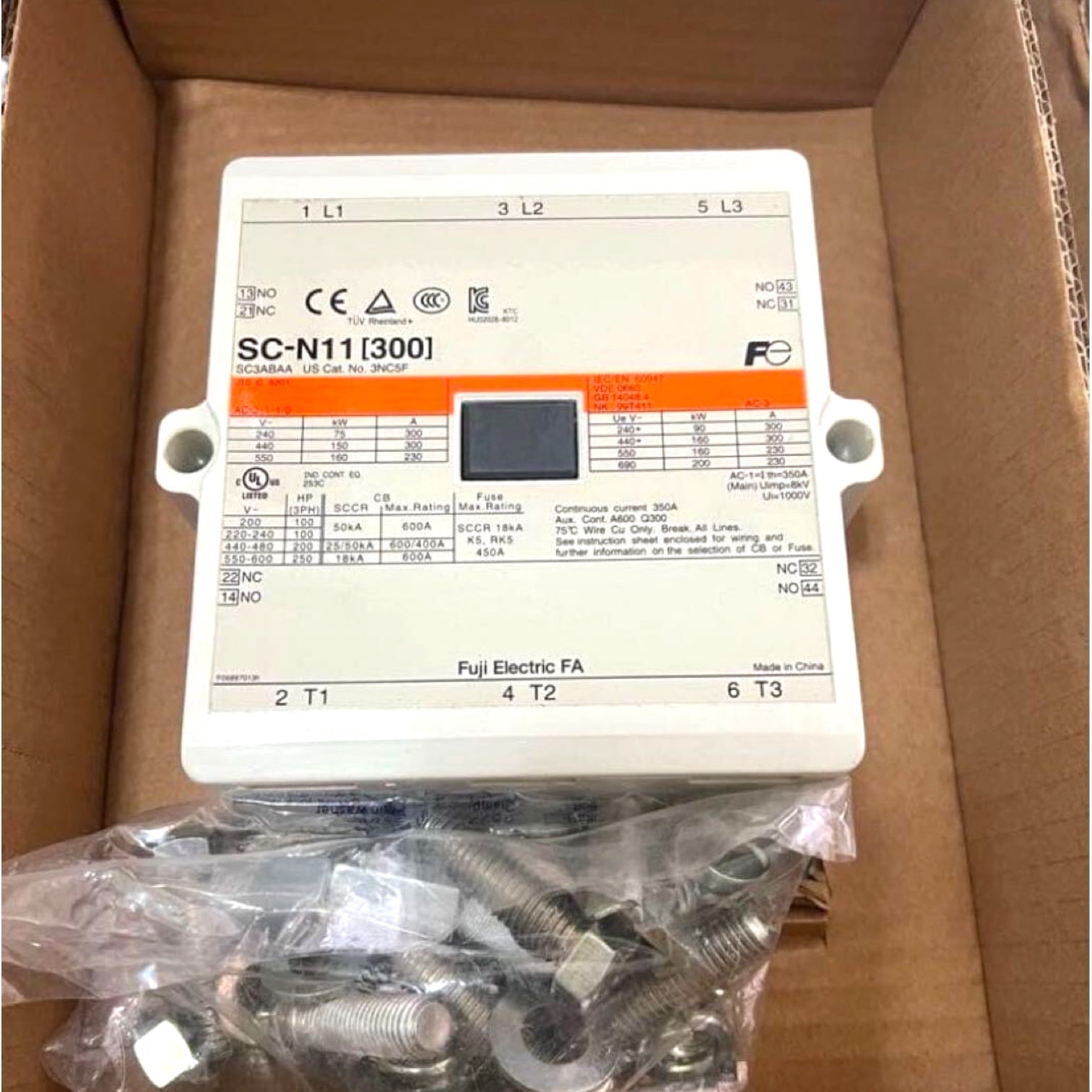 A Fujitsu Electric SC-N11[300] electrical fuse holder box with a small display screen, shown inside its cardboard box packaging with mounting hardware below.