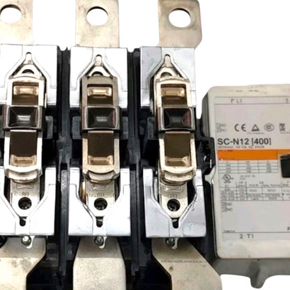 Three large industrial contactors with silver metal terminals and black plastic housings, shown next to a white molded electronic component labeled SC-N12 [400].