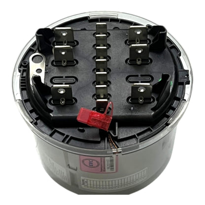 A cylindrical industrial electrical component, likely a terminal block or motor drive, featuring a black internal terminal assembly with metal contacts, a red plastic connector, and a gray outer casing with a clear top cover.