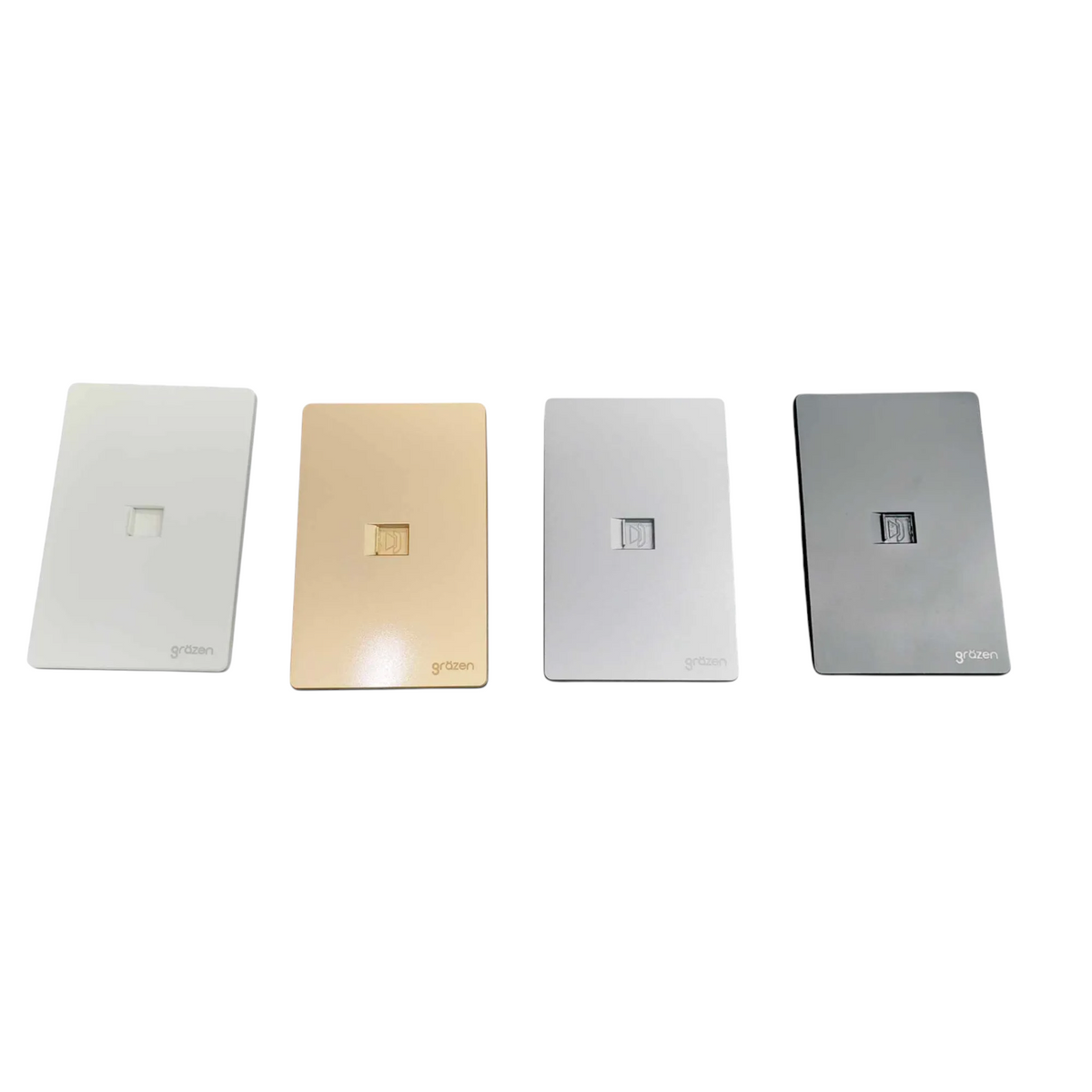 Four rectangular wall outlets in different finishes lined up horizontally on a white background: white, champagne gold, silver, and dark gray. Each outlet has a small square cutout in the center and the brand name 'g&g' printed at the bottom left.