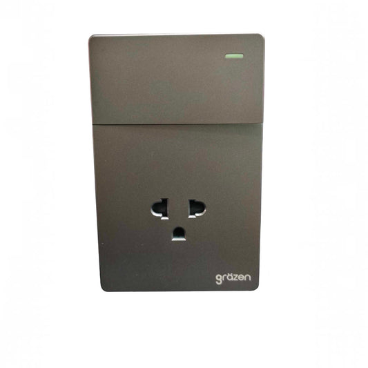 A dark gray wall-mounted power adapter or outlet with a three-pin UK-style plug, featuring a small green indicator light at the top and the brand name 'gräzen' printed in white at the bottom right.