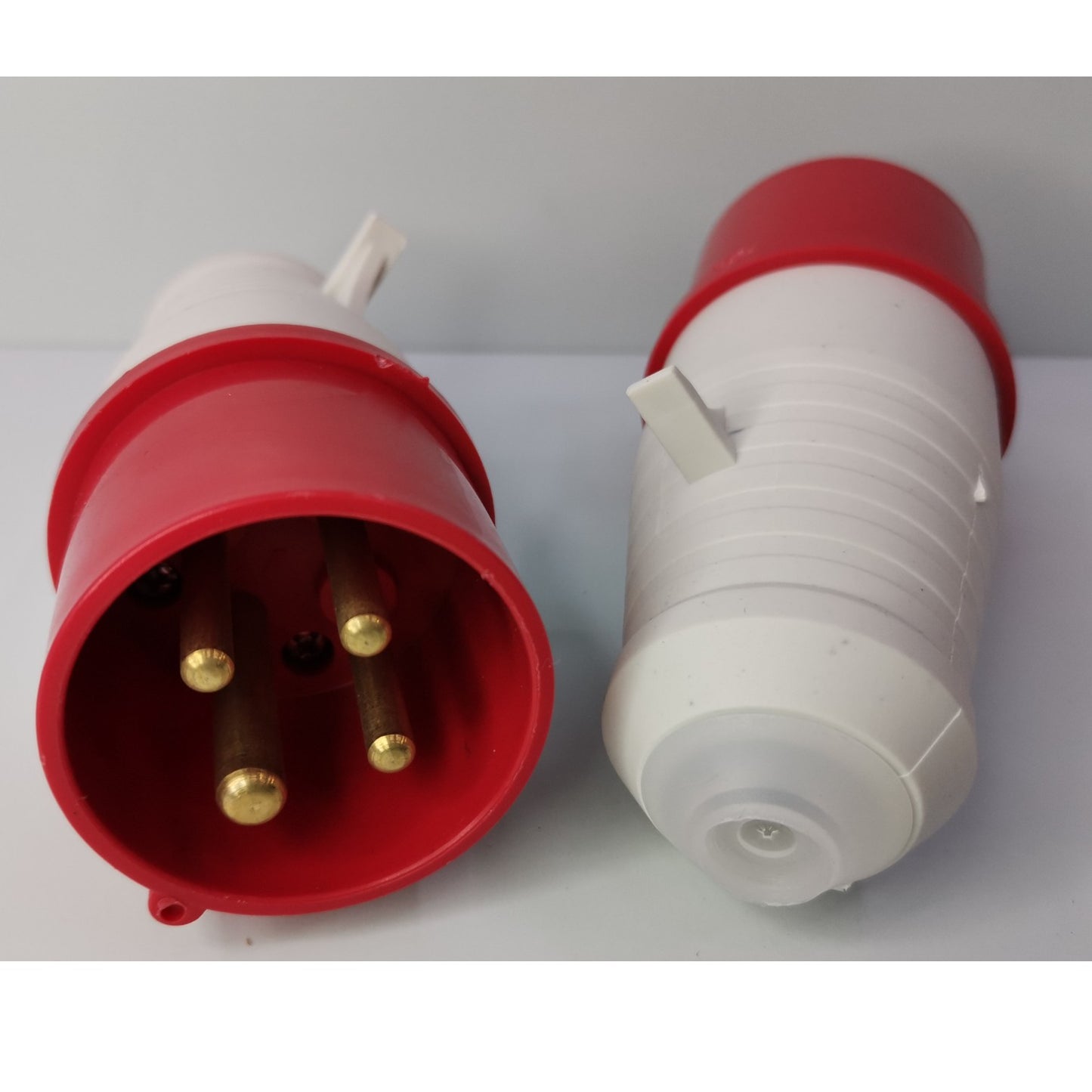 Red and white electrical plug on a light gray background