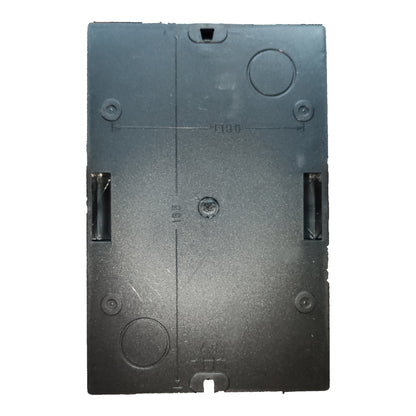 Black rectangular object with circular and rectangular cutouts on a white background