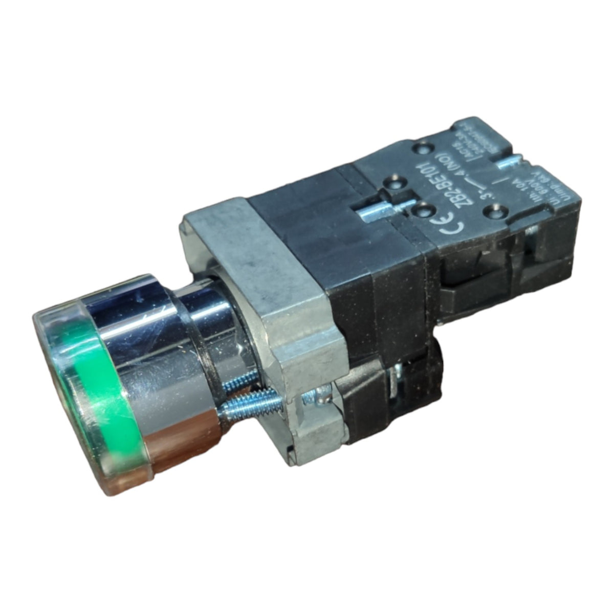 An industrial push-button switch with a silver metal housing, a clear protective cover, and a green illuminated lens.