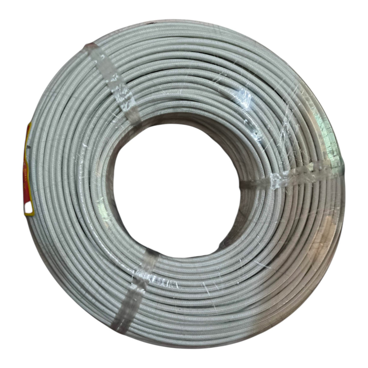 A coiled roll of light gray cable or wire wrapped in clear plastic, photographed against a plain white background.