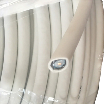 A close-up of a coiled light beige or off-white cable wrapped in clear plastic, with one end exposed showing a blue-gray inner core and a small gold center.