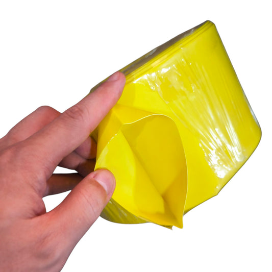 Hand holding a roll of yellow tape against a white background