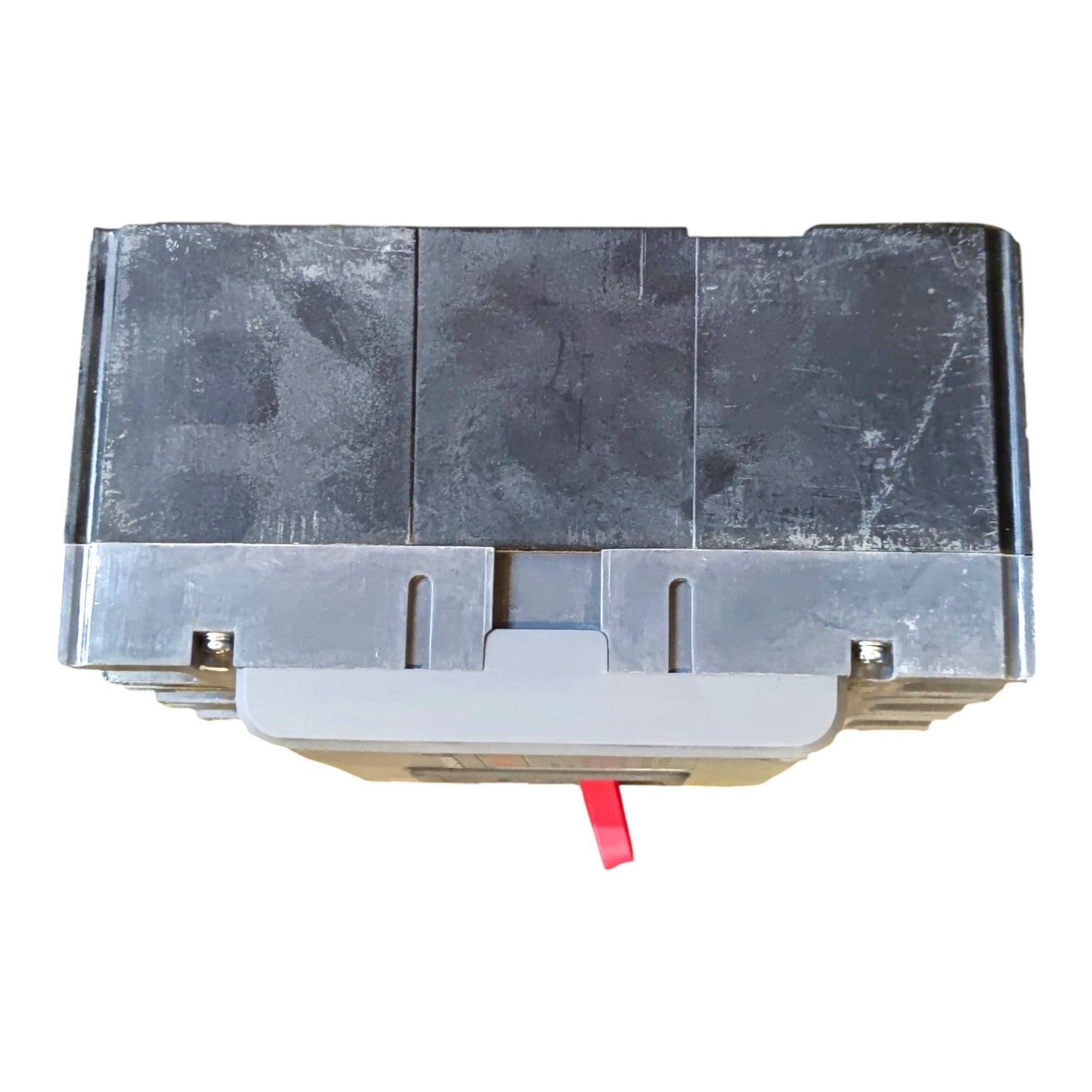 A used black plastic automotive or industrial component housing with a gray metal base and a small red tab protruding from the front, shown on a white background.