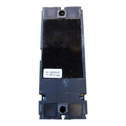 A heavy-duty industrial electrical contactor or relay component, shown from the back. The unit is primarily black with a textured central panel, mounting screws at the base, and a small white label with printed barcodes and text.