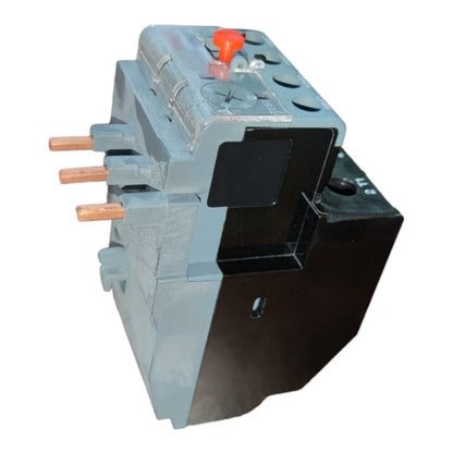 An industrial electrical contactor or relay component with a gray and black body, featuring three copper-colored terminal studs on the left and a small red switch on top, shown against a plain white background.
