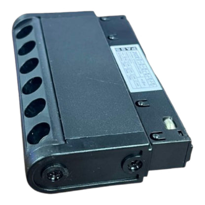 A black plastic electrical terminal block or connector module with multiple circular mounting holes on one side and a white specification label, shown on a plain white background.