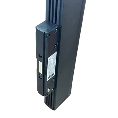A close-up of a black electronic device, likely a door alarm receiver or security sensor module, showing its side profile, ports, and a white label with technical specifications, set against a plain white background.