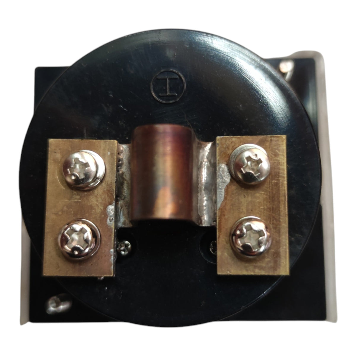 A close-up of an electrical component or relay with a black circular body, a copper-colored center coil, and two brass terminal blocks secured with silver screws.