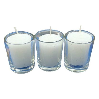 Three white candles in clear glass holders on a white background