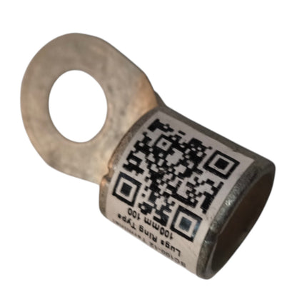 A metal ring terminal lug with a white label featuring a black QR code and printed text, isolated on a white background.