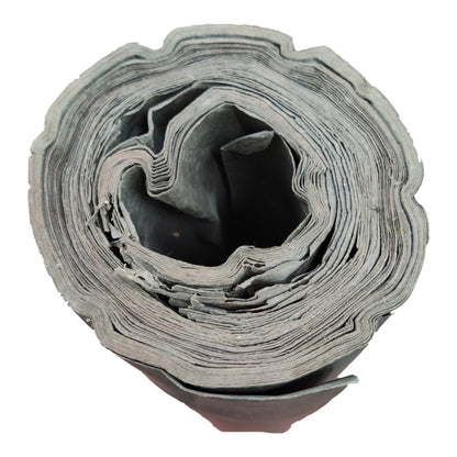A rolled-up gray fabric or material sample with layered, scalloped edges, shown on a plain white background.