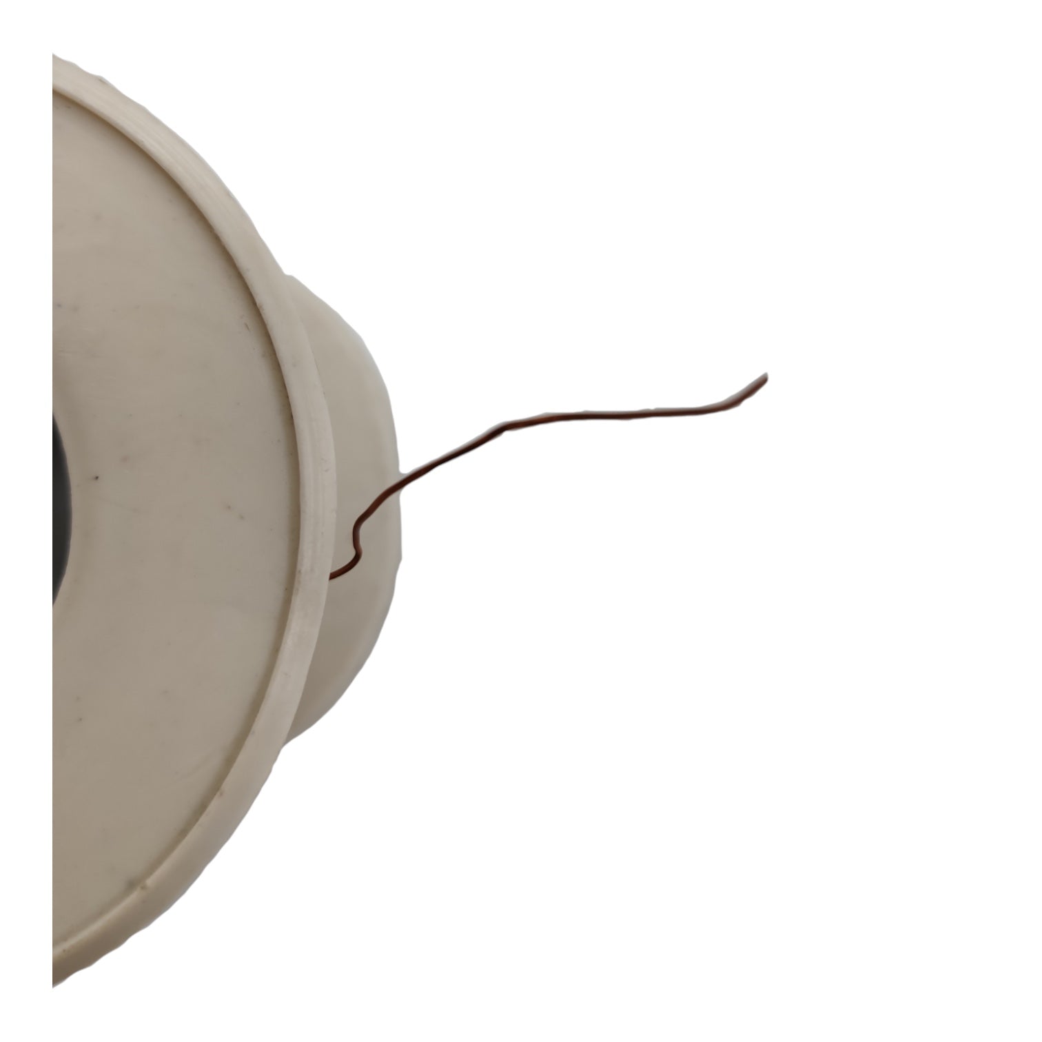A close-up of a beige plastic circular component with a thin brown wire attached to it, isolated on a white background.