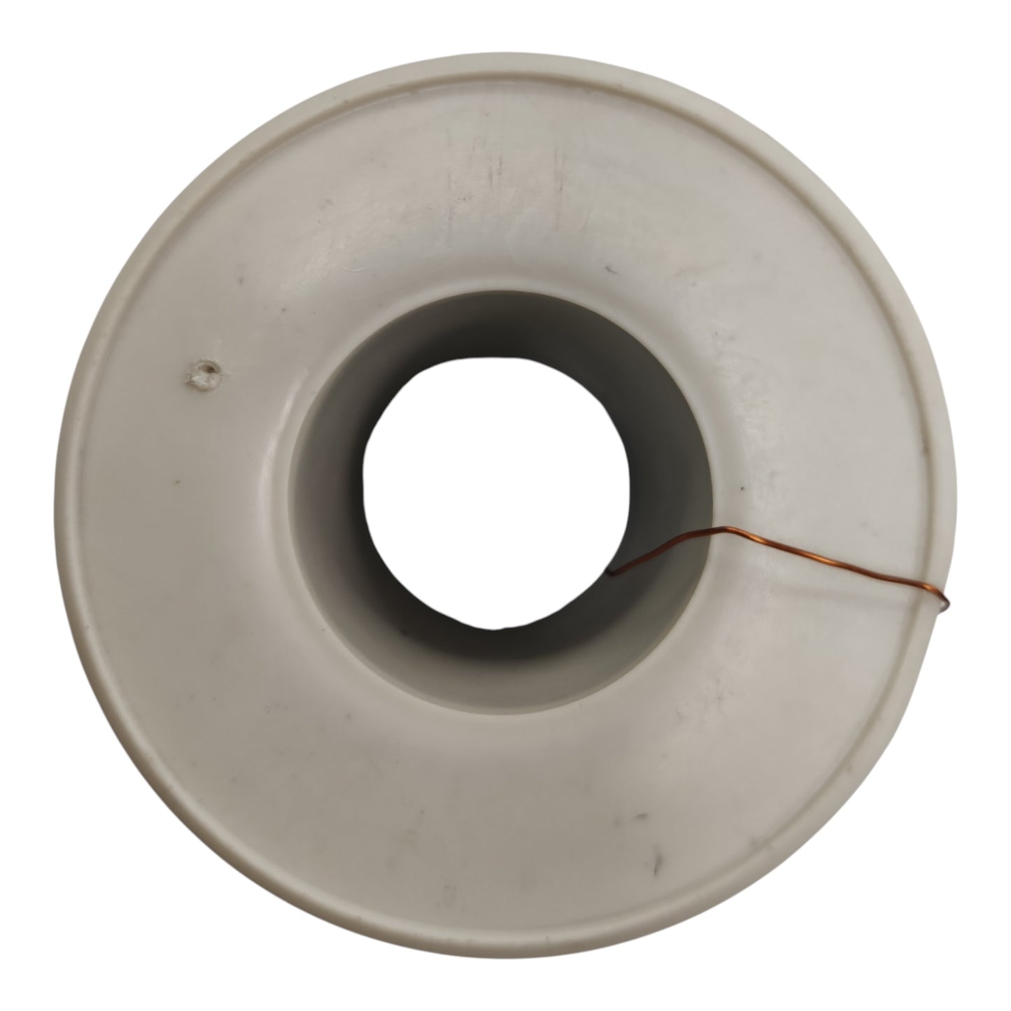 A circular off-white plastic or ceramic ring-shaped component with a central hole and a thin copper wire wrapped around it, shown on a plain white background.