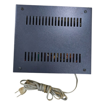 Rectangular metal device with ventilation grilles and a power cord on a white background