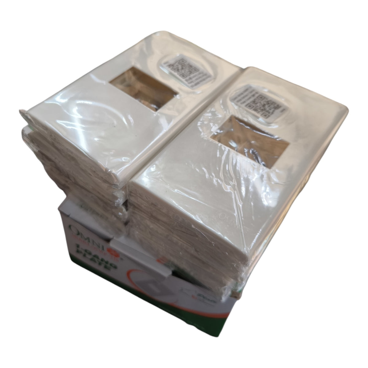 A stack of white paper napkins wrapped in clear plastic, with a cardboard insert and printed box base visible underneath on a plain white background.