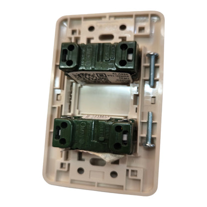 A single light switch plate backplate shown open, revealing two dark green terminal blocks and two silver mounting screws on a white background.