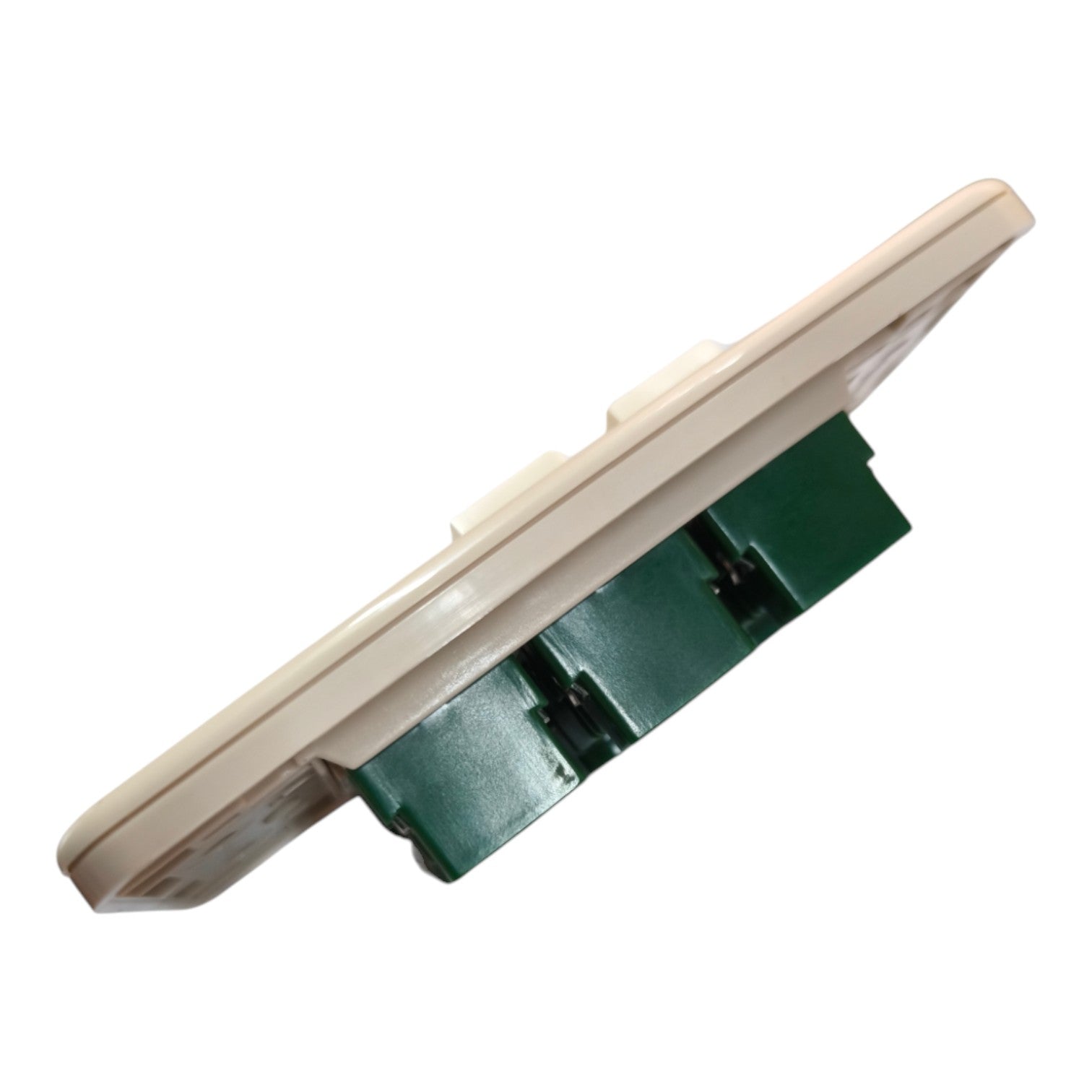A close-up of a beige plastic switch or outlet component showing its side profile and green mounting base, isolated on a white background.