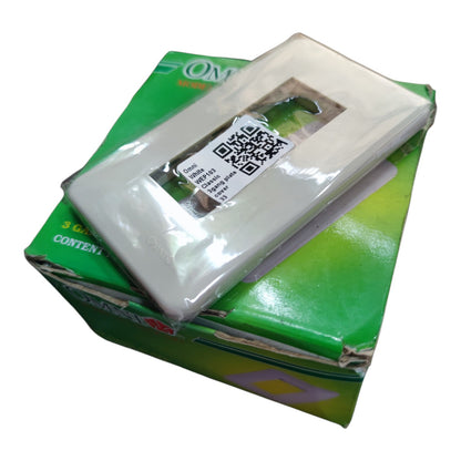 Three white plastic outlet covers in clear plastic wrapping, stacked on top of their green cardboard packaging box.