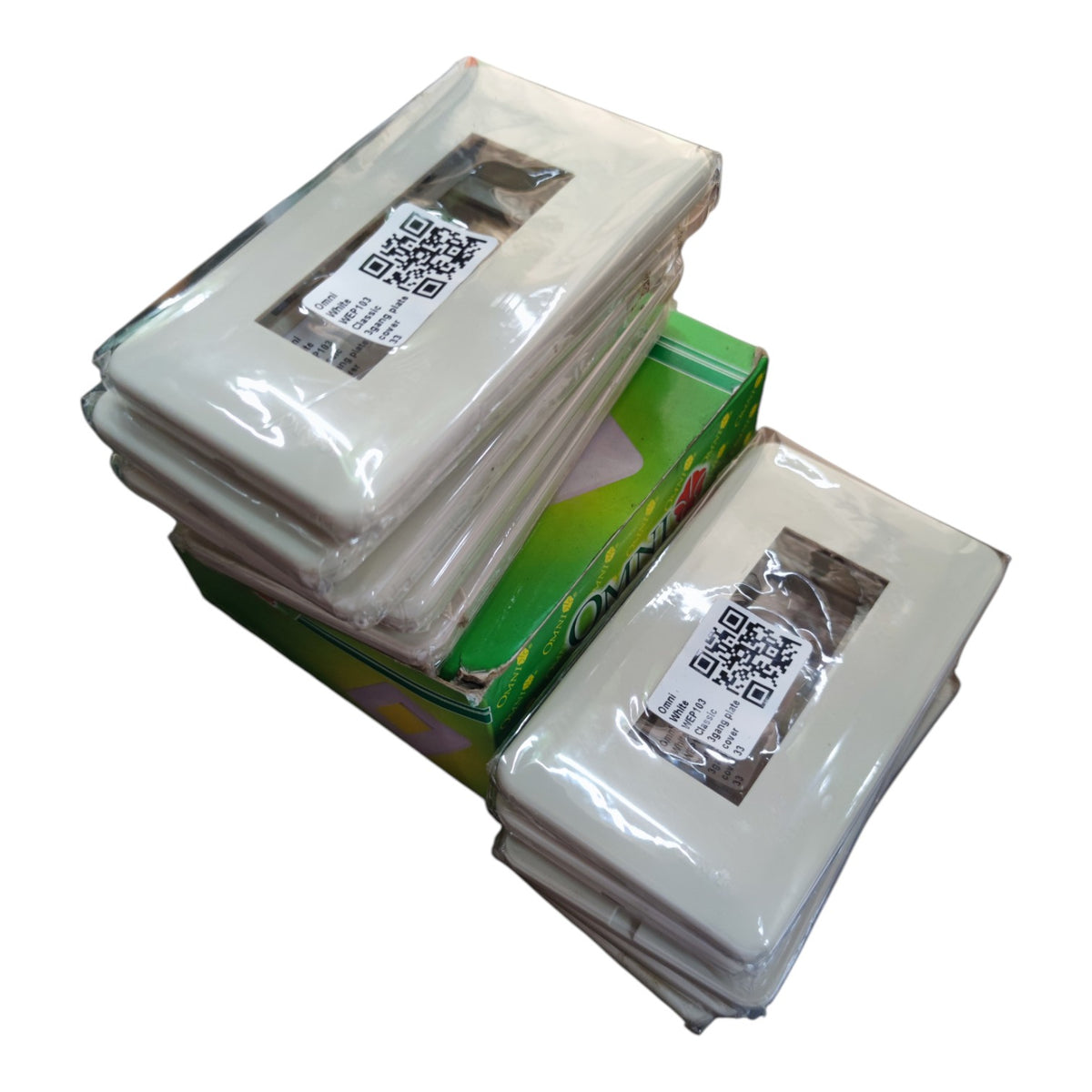 Three stacks of clear plastic-wrapped square inserts or cards with QR code labels, arranged on top of a green box against a plain white background.