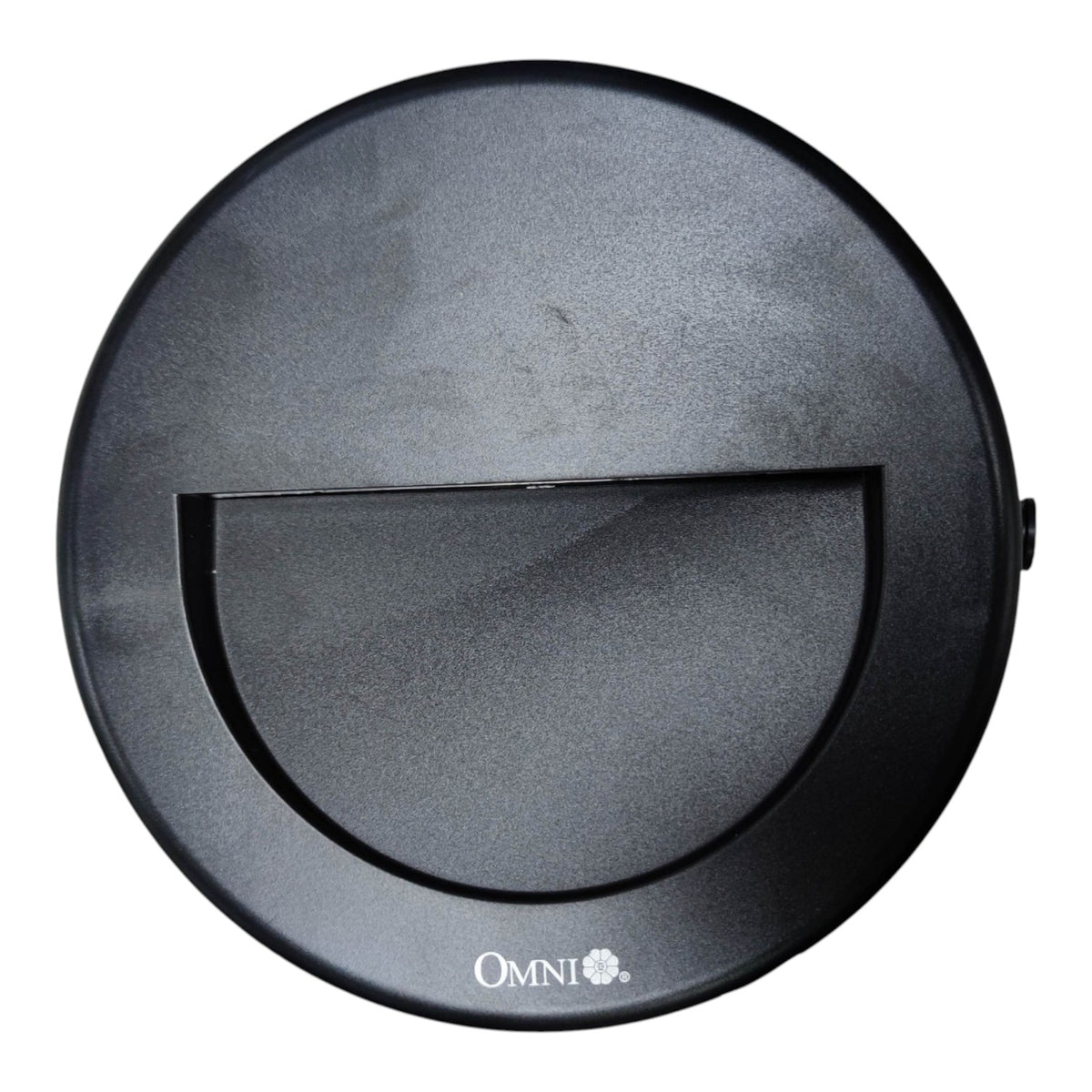 A top-down view of a black circular robotic vacuum cleaner lid, featuring a central semi-circular cutout and the 'OMNI+' brand logo printed in white at the bottom.
